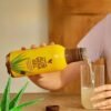 Mano sirviendo Forever Aloe Vera Gel en un vaso