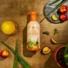 Botella de Forever Aloe Peaches sobre una mesa de madera con duraznos